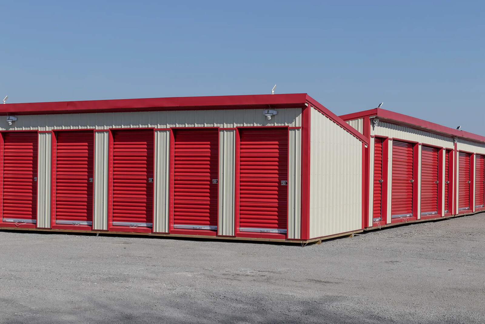 Pest Control - Storage Unit - Atlanta, GA Storage units with red roll-up doors in a commercial setting, representing space for pest control equipment and supplies for Monitor Pest Control services in Atlanta, GA.